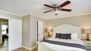 A bedroom with a white bed, a ceiling fan, two bedside lamps, and a door leading to another room. - Tuscon Vacation Rental < 1 Mi to Golf Course! (Tucson)