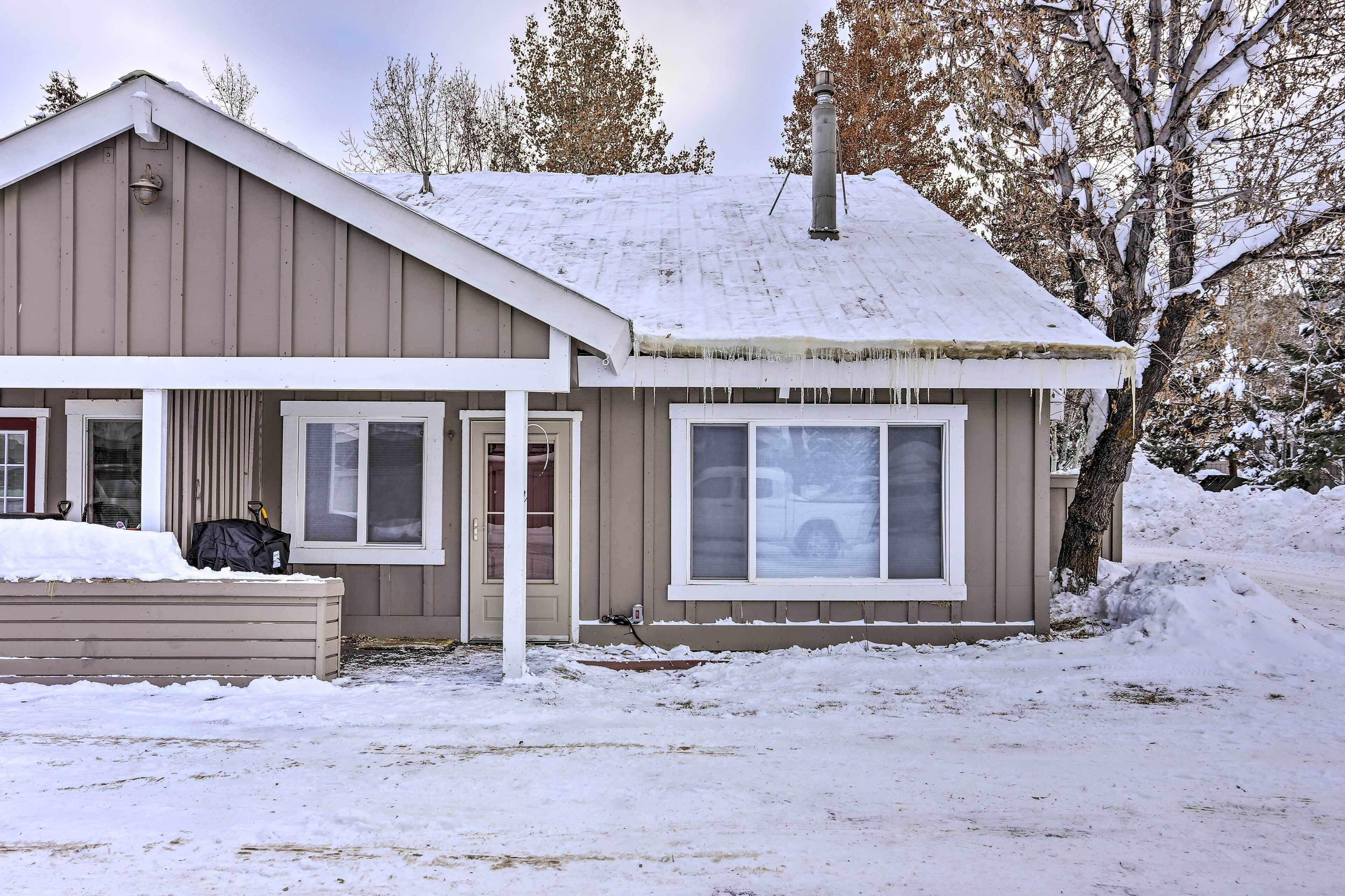 A two-story house with a snow-covered roof and a front porch.