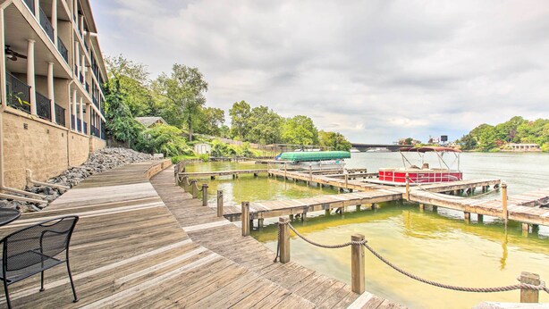 Une terrasse en bois offrant une vue sur une rivière et des bateaux amarrés.