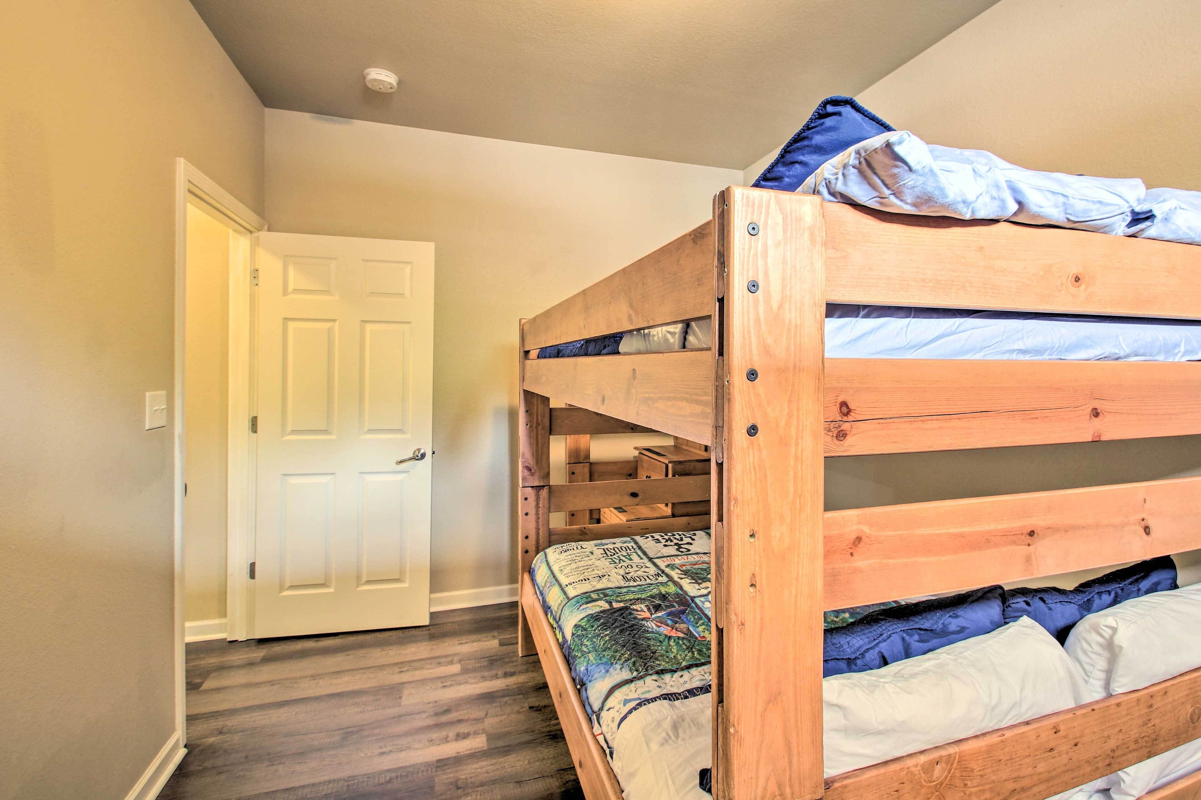 A bunk bed with a lower bunk and a door to the left.
