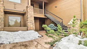 A two-story house with a stone facade, a wooden exterior, and a staircase leading to a balcony. - Golf Course View: Torreon Vacation Rental! (Show Low)