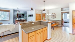 A modern kitchen with granite countertops, wooden cabinets, and pendant lighting. - Golf Course View: Torreon Vacation Rental! (Show Low)