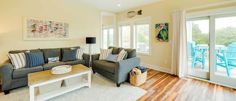 A living room with a sofa, coffee table, and a ceiling fan.