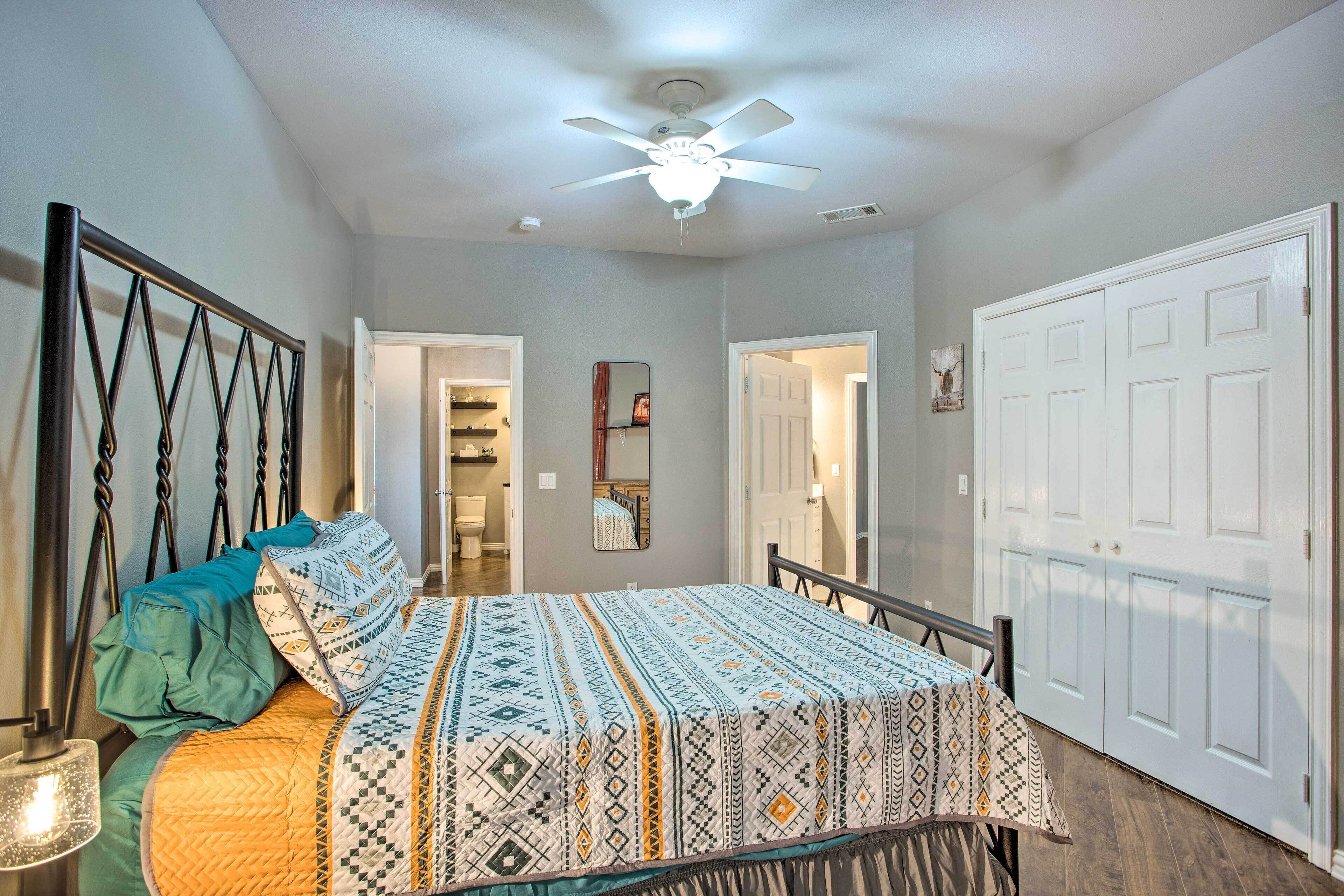 A bedroom with a bed, a ceiling fan, and a wardrobe.