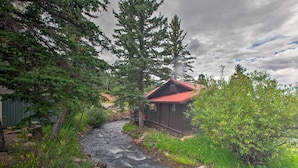 A cabin by a flowing stream surrounded by dense forest. - Relaxing Cuchara Retreat on Cucharas River w/ View (La Veta)