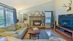 A living room with a fireplace, a television, and a sofa. - Home w/ Hot Tub: 7 Mi to Edmonds Waterfront! (Lynnwood)