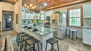 A spacious kitchen with a large island, stainless steel appliances, and a wooden ceiling. - Otto Home w/ Fire Pit, Tree House & Hot Tub! (Otto)