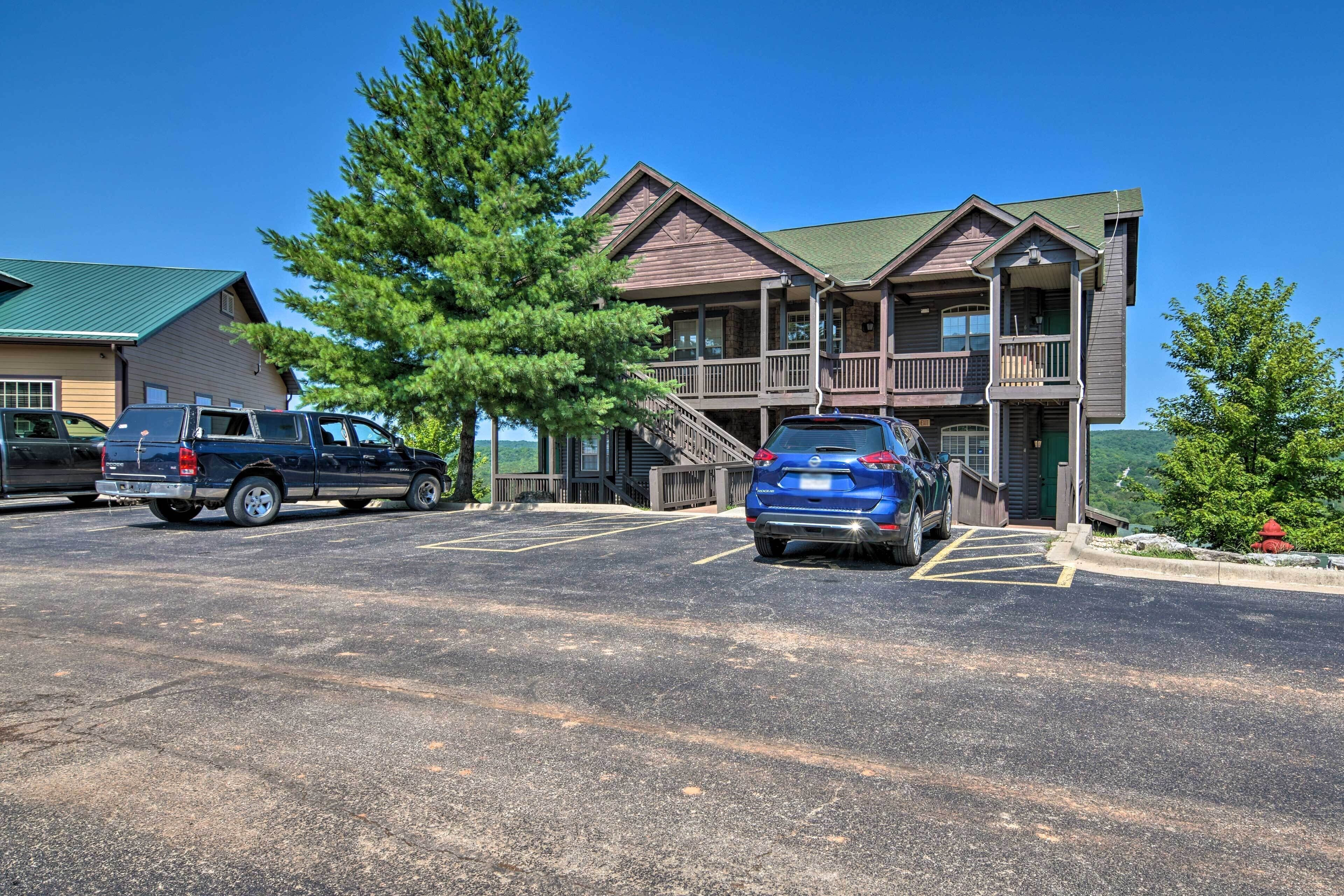 A multi-story building with a porch and a parking lot.