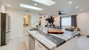 A modern kitchen with a marble countertop, built-in appliances, and a skylight. - High-end & Luxe Scottsdale Gem w/ Pool & Yard (Scottsdale)