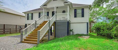 A two-story house with a front porch, a staircase leading to the second floor, and a garage.