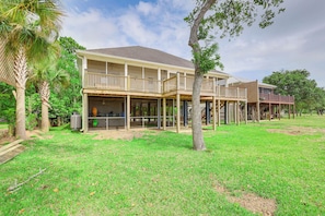 A two-story house with a covered patio and a large lawn. - Foley Beach Cottage w/ Waterfront Backyard! (Foley)
