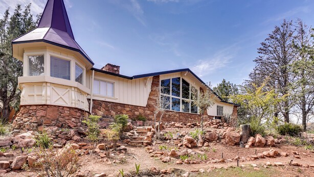 A house with a stone foundation, a large window, and a distinctive tower. - 6 Mi to Red Rock State Park: Home w/ Patio & Yard (Sedona)