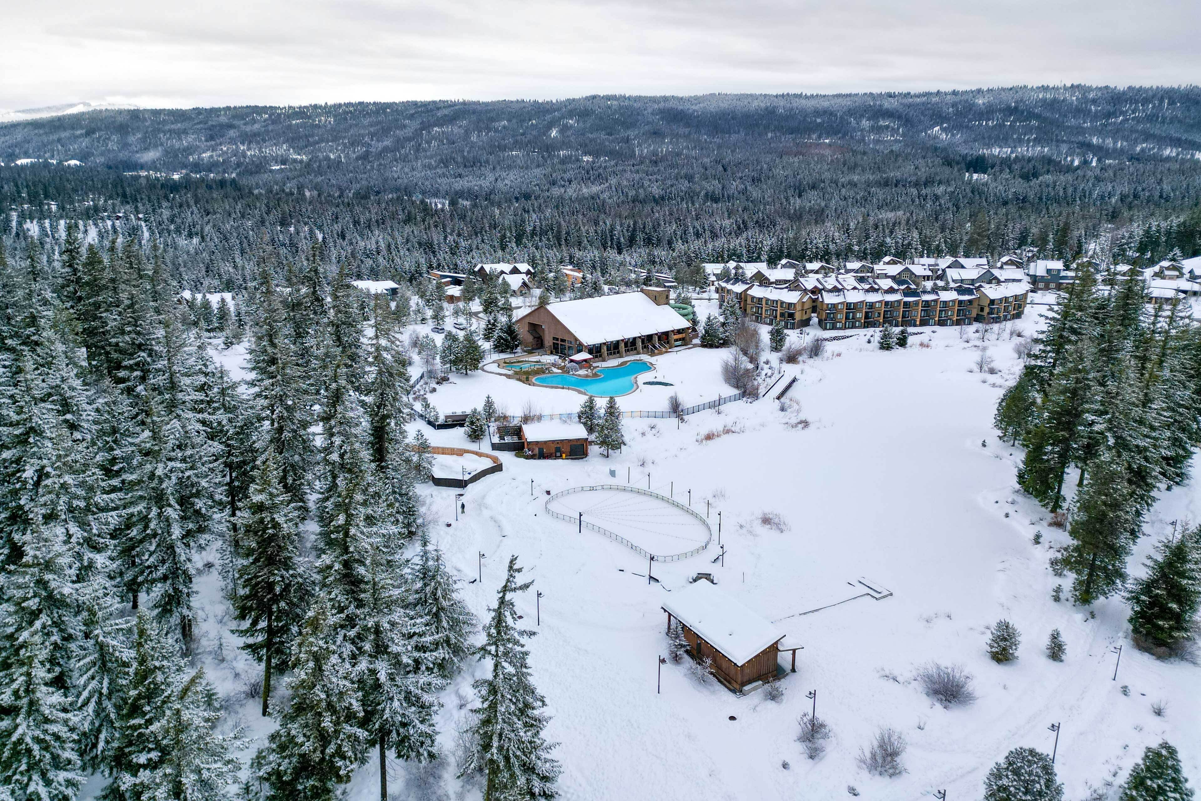 Un complexe hôtelier doté d’une grande piscine, de plusieurs bâtiments et offrant un paysage enneigé.