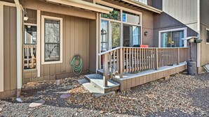 A wooden house with a porch, steps, and a garden area with gravel and mulch. - Relaxing Deck & Grill: Pinetop Townhome! (Pinetop)