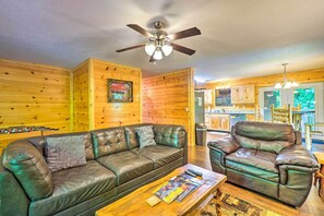 A cozy living room with a leather sofa, a wooden coffee table, and a ceiling fan. - Cozy Gatlinburg Hideaway w/ Private Hot Tub! (Gatlinburg)