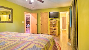 A bedroom with a bed, a ceiling fan, a television, a wooden dresser, and a closet. - Cozy Gatlinburg Hideaway w/ Private Hot Tub! (Gatlinburg)