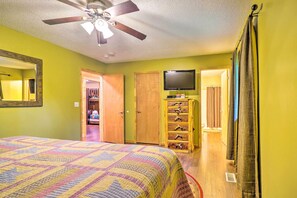 A bedroom with a bed, a ceiling fan, a television, a wooden dresser, and a closet. - Cozy Gatlinburg Hideaway w/ Private Hot Tub! (Gatlinburg)