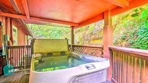 A hot tub on a wooden deck with a view of a forested area. - Cozy Gatlinburg Hideaway w/ Private Hot Tub! (Gatlinburg)