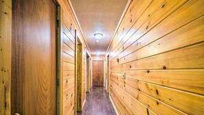 A wooden hallway with a door on the left and a door at the end. - Cozy Gatlinburg Hideaway w/ Private Hot Tub! (Gatlinburg)
