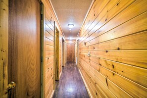 A wooden hallway with a door on the left and a door at the end. - Cozy Gatlinburg Hideaway w/ Private Hot Tub! (Gatlinburg)