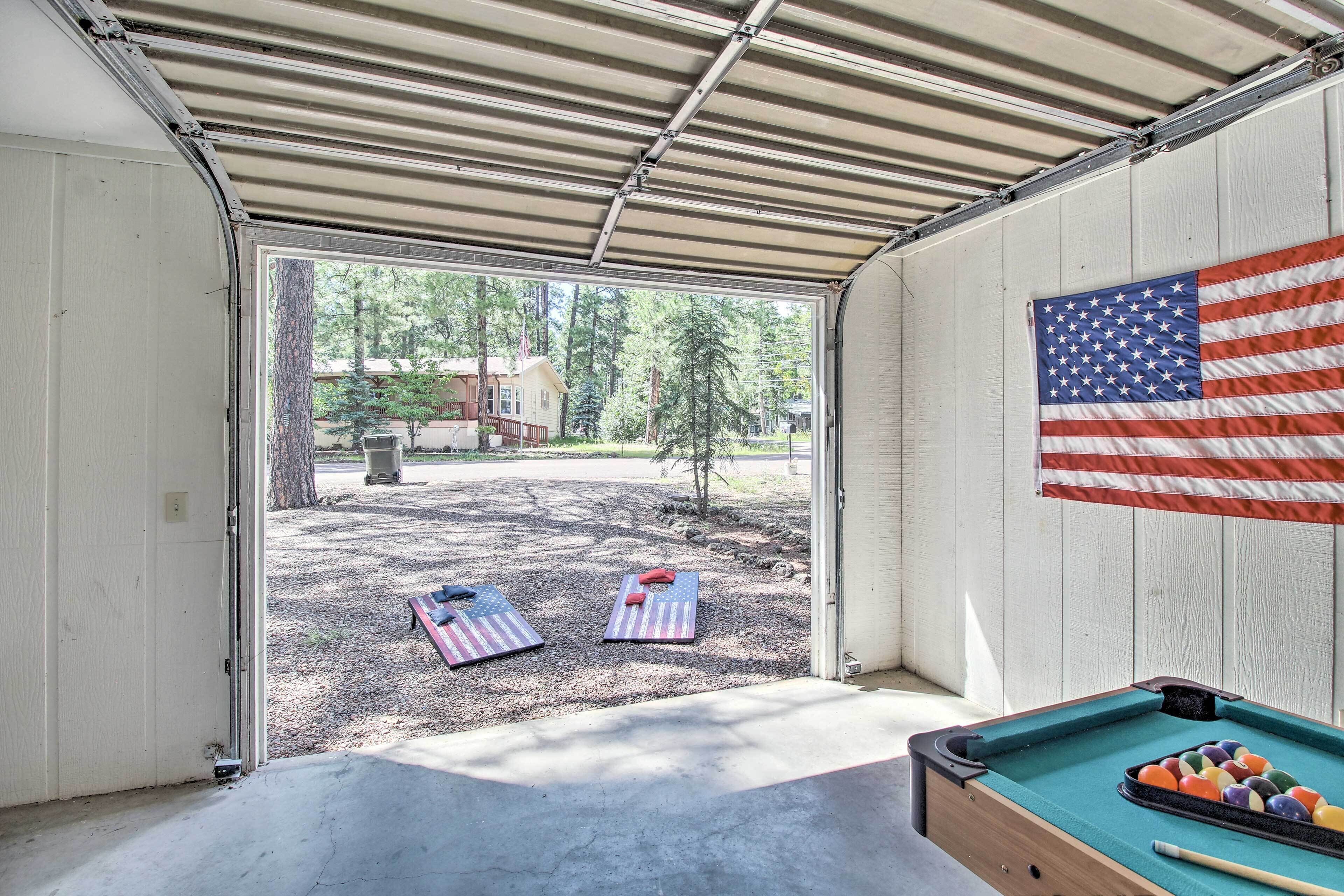 Una mesa de billar con taco y bolas, una bandera y dos colchonetas de yoga afuera de un edificio.