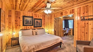 Ein Schlafzimmer mit Holzwänden, einem Bett, einem Schreibtisch und einem Stuhl.