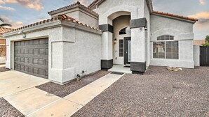 Una casa moderna con garage, ingresso coperto e vialetto curato.