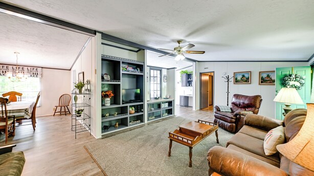 A spacious living room with a wooden coffee table, leather sofa, and a bookshelf. - Quiet 'horseshoe Hill House' By Lake Barkley! (Cadiz)