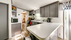 A modern kitchen with grey cabinets, a white countertop, and a sign that reads "LIFE IS BETTER AT THE LAKE". - Quiet 'horseshoe Hill House' By Lake Barkley! (Cadiz)