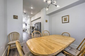 Ein Essbereich mit einem Holztisch und Stühlen, einer Kandelaber und einer Küche im Hintergrund.