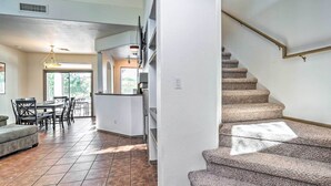 A spacious living area with a dining table and chairs, a kitchen area with a white countertop, and a stone staircase. - Cave Creek Retreat w/ Private Pool & Hot Tub! (Cave Creek)