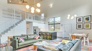 A modern living room with a sofa, coffee table, and dining area with chairs and a table. - Nature Lovers' Paradise! Luxe Retreat w/ Game Room (Salem)
