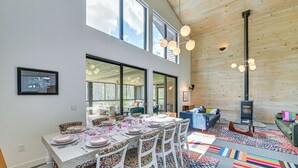 A dining area with a long table set for six, surrounded by chairs with colorful patterns. - Nature Lovers' Paradise! Luxe Retreat w/ Game Room (Salem)