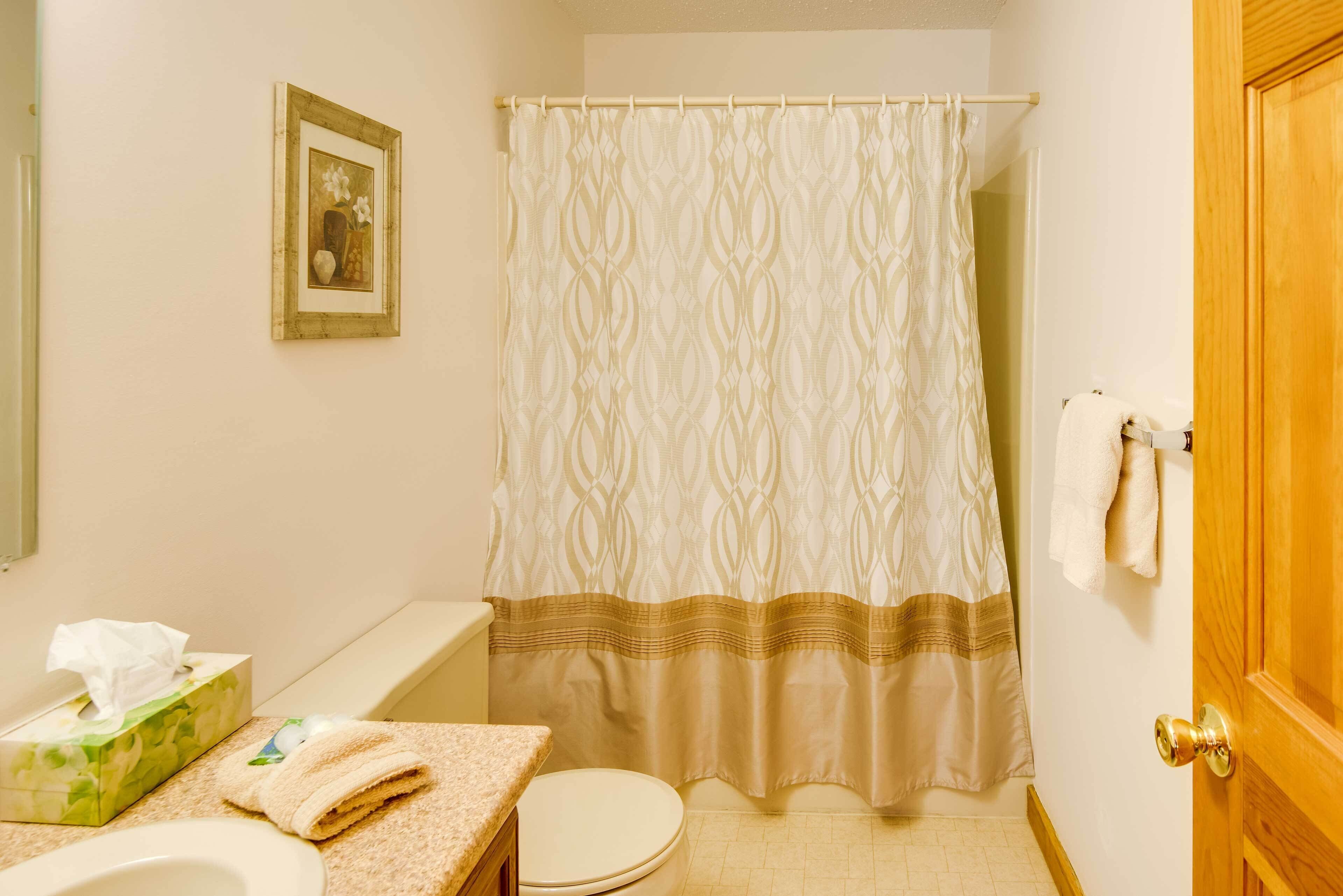 Un baño con inodoro, lavabo y cortina de ducha.