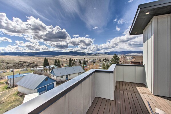 A balcony with a view of a town and mountains.