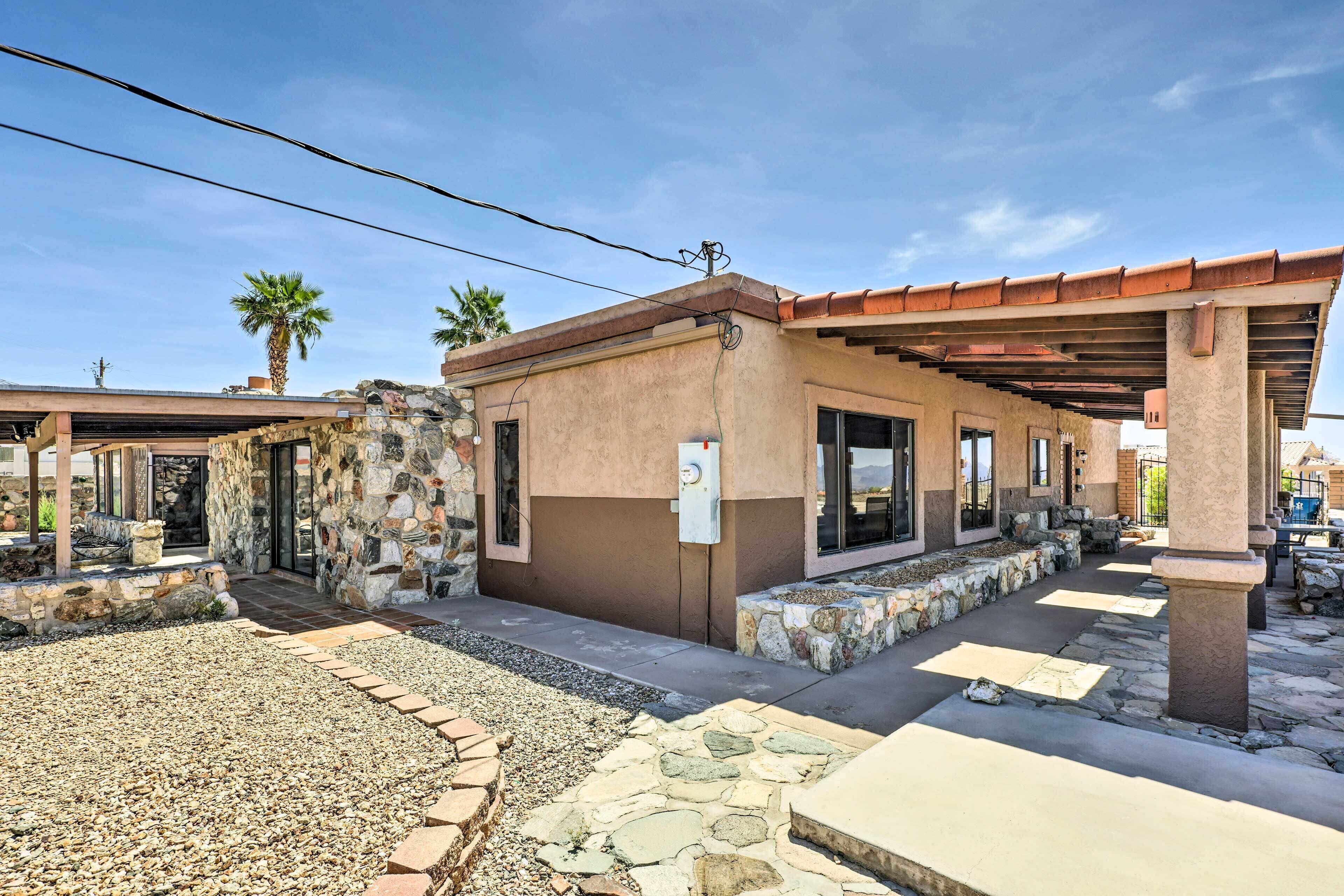 A building with a stone facade, a covered patio area, and a gravel pathway.
