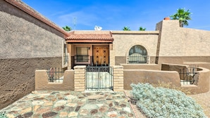A traditional building with a tiled roof, a stone facade, and a gated entrance. - Patio & Panoramic Views: Hillside Lake Havasu Home (Lake Havasu City)