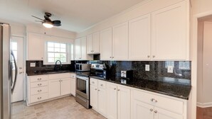 A modern kitchen with white cabinets, stainless steel appliances, and a granite countertop. - North Carolina Retreat - Deck, Grill & Creek Views (Beaufort)