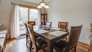 A dining area with a wooden table, chairs, and a chandelier. - Sporty Blaine Home w/ Games ~ 2 Mi to Super Rink! (Blaine)
