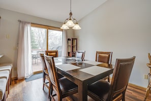 A dining area with a wooden table, chairs, and a chandelier. - Sporty Blaine Home w/ Games ~ 2 Mi to Super Rink! (Blaine)