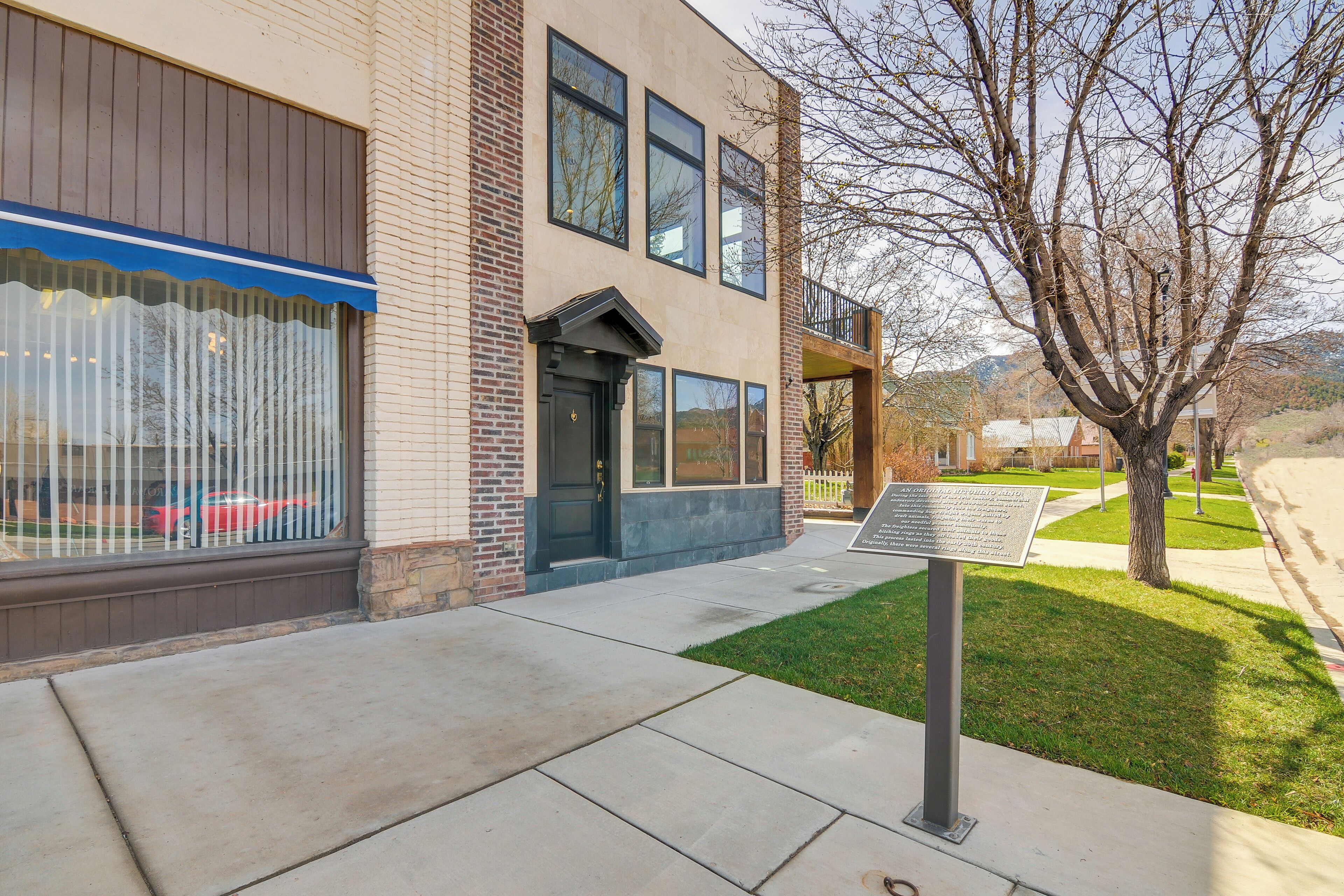 A building with a brick facade, large windows, and a clear sky.
