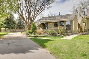 A single-story house with a front porch, a driveway, and a well-maintained lawn.