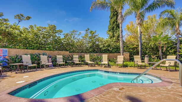 A swimming pool with lounge chairs and palm trees. - Family-friendly Camarillo Home w/ Access to Pools! (Camarillo)