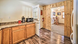 A kitchen with wooden cabinets, a microwave, and a refrigerator. - Sunroom, Deck & Grills: Marquette Cottage! (Marquette)