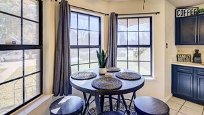 A kitchen with dark blue cabinets, a ceiling fan, and a window with curtains. - 4 Mi to Joe Pool Lake: Home in Grand Prairie (Grand Prairie)