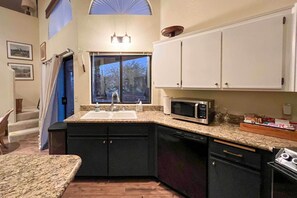 A kitchen with granite countertops, a sink, a microwave, and black cabinets. - Borrego Springs Retreat w/ Grill & Patio! (Borrego Springs)