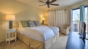 A bedroom with a bed, bedside lamps, a ceiling fan, a chair, a desk, and a window with curtains. - Borrego Springs Retreat w/ Grill & Patio! (Borrego Springs)