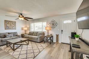 A living room with a ceiling fan, two sofas, a coffee table, a rug, a side table with a lamp, and a TV on a stand. - 2 Mi to Lake Havasu: Home w/ Patio! (Lake Havasu City)