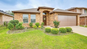 A two-story house with a brick facade, a front porch, and a garage.
