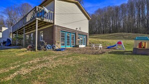 A two-story building with a balcony, a play area with a slide, and a small playhouse. - Pet-friendly Home w/ Grill & Farm in Meadowview! (Meadowview)